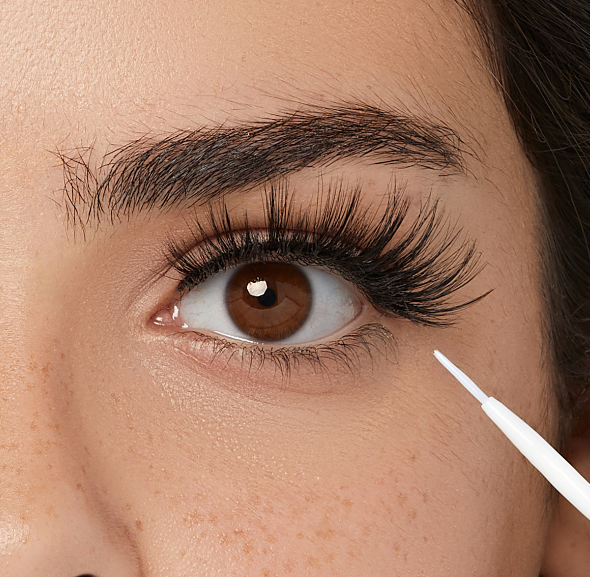 Pegamento KISS para pestañas con aloe vera mostrando fórmula transparente y aplicador fino de precisión